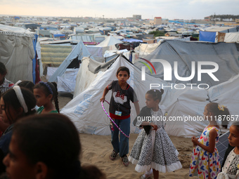 Palestinian children are attending class at a makeshift school in a camp for displaced Palestinians in Deir El-Balah, in the central Gaza St...