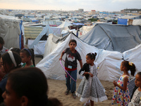 Palestinian children are attending class at a makeshift school in a camp for displaced Palestinians in Deir El-Balah, in the central Gaza St...