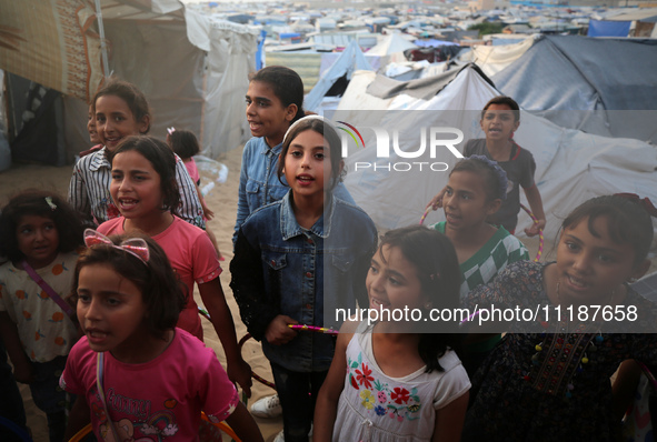 Palestinian children are attending class at a makeshift school in a camp for displaced Palestinians in Deir El-Balah, in the central Gaza St...