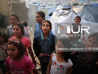 Palestinian children are attending class at a makeshift school in a camp for displaced Palestinians in Deir El-Balah, in the central Gaza St...