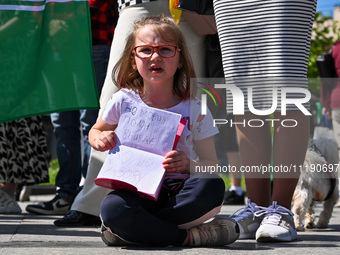 A girl is holding a copybook with a slogan written in it during the FreeAzov action in support of the military held in Russian captivity, at...