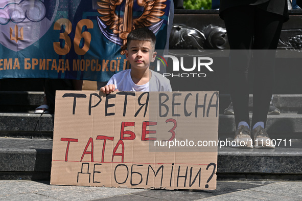 A boy is holding a placard during the FreeAzov action in support of the military held in Russian captivity, at the square at the Taras Shevc...