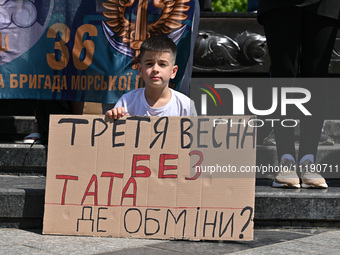 A boy is holding a placard during the FreeAzov action in support of the military held in Russian captivity, at the square at the Taras Shevc...