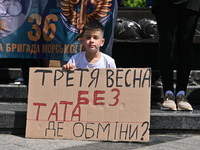 A boy is holding a placard during the FreeAzov action in support of the military held in Russian captivity, at the square at the Taras Shevc...