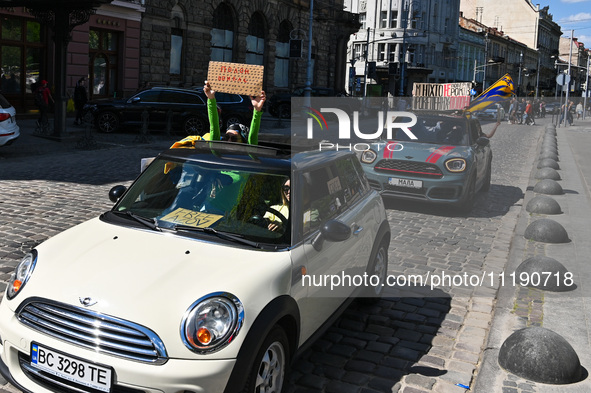 People in cars are holding placards during the FreeAzov action in support of the military held in Russian captivity in Lviv, Ukraine, on Apr...