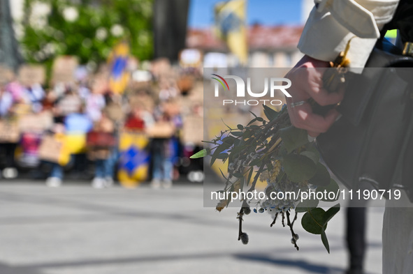 A participant is holding flowers and willow sprigs during the FreeAzov action in support of the military held in Russian captivity in Lviv,...