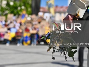 A participant is holding flowers and willow sprigs during the FreeAzov action in support of the military held in Russian captivity in Lviv,...