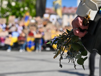 A participant is holding flowers and willow sprigs during the FreeAzov action in support of the military held in Russian captivity in Lviv,...