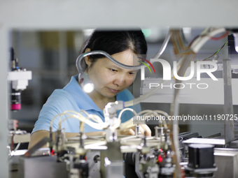 A worker is producing electronic products at a workshop in Nanchong, Sichuan Province, China, on April 29, 2024. (