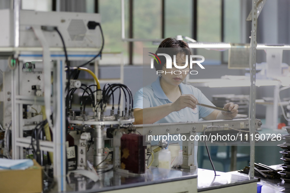 A worker is producing electronic products at a workshop in Nanchong, Sichuan Province, China, on April 29, 2024. 