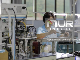 A worker is producing electronic products at a workshop in Nanchong, Sichuan Province, China, on April 29, 2024. (