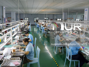 A worker is producing electronic products at a workshop in Nanchong, Sichuan Province, China, on April 29, 2024. (