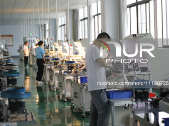 A worker is producing electronic products at a workshop in Nanchong, Sichuan Province, China, on April 29, 2024. (