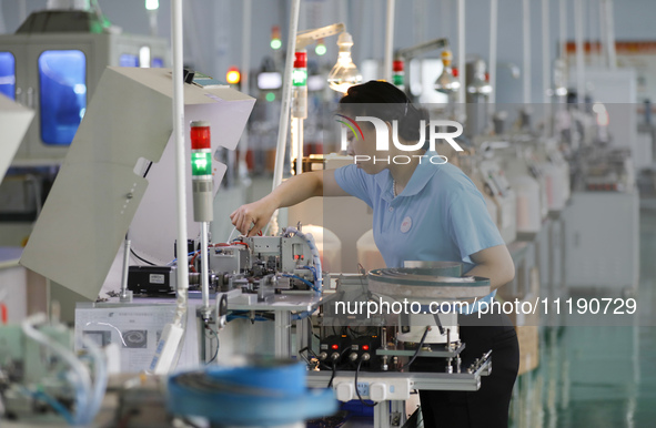 A worker is producing electronic products at a workshop in Nanchong, Sichuan Province, China, on April 29, 2024. 