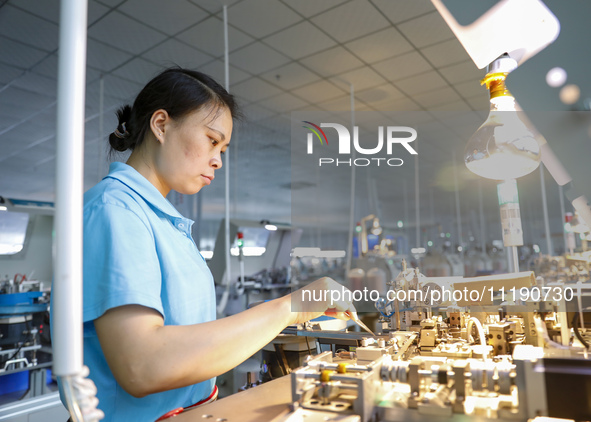 A worker is producing electronic products at a workshop in Nanchong, Sichuan Province, China, on April 29, 2024. 