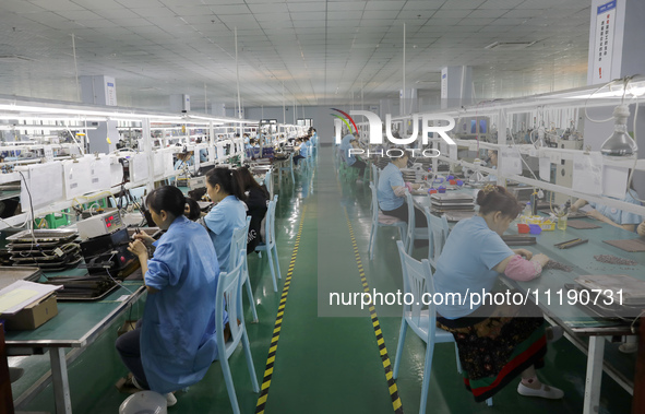 A worker is producing electronic products at a workshop in Nanchong, Sichuan Province, China, on April 29, 2024. 