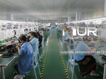 A worker is producing electronic products at a workshop in Nanchong, Sichuan Province, China, on April 29, 2024. (