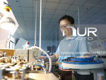 A worker is producing electronic products at a workshop in Nanchong, Sichuan Province, China, on April 29, 2024. (