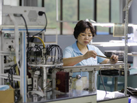 A worker is producing electronic products at a workshop in Nanchong, Sichuan Province, China, on April 29, 2024. (