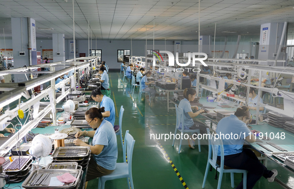 A worker is producing electronic products at a workshop in Nanchong, Sichuan Province, China, on April 29, 2024. 