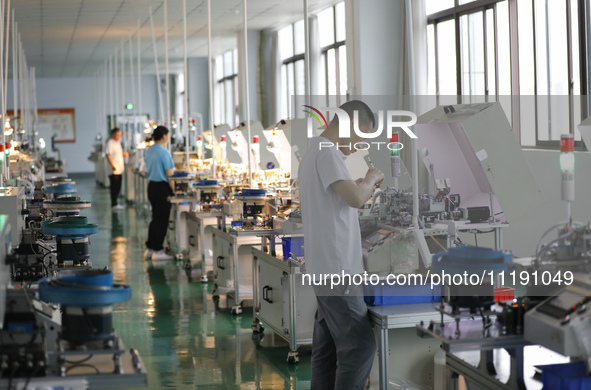 A worker is producing electronic products at a workshop in Nanchong, Sichuan Province, China, on April 29, 2024. 