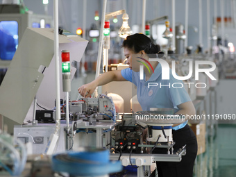 A worker is producing electronic products at a workshop in Nanchong, Sichuan Province, China, on April 29, 2024. (