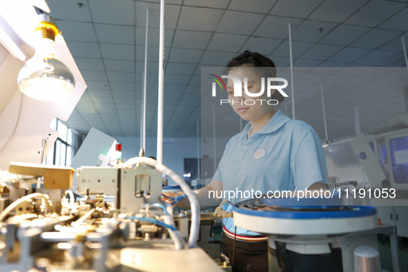 A worker is producing electronic products at a workshop in Nanchong, Sichuan Province, China, on April 29, 2024. 