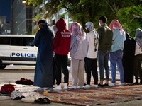 Muslim students pray at sunrise at a Gaza solidarity encampment at George Washington University, while a DC police van blocks the street, Wa...