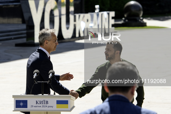 Ukraine's President Volodymyr Zelenskiy and NATO Secretary-General Jens Stoltenberg shake hands after a joint press conference, amid Russia'...