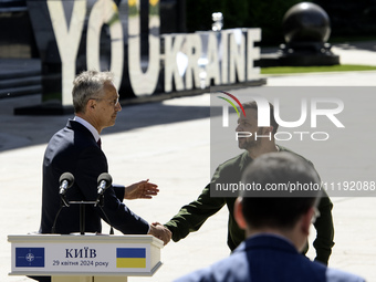 Ukraine's President Volodymyr Zelenskiy and NATO Secretary-General Jens Stoltenberg shake hands after a joint press conference, amid Russia'...