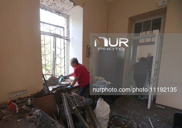 KHARKIV, UKRAINE - APRIL 27, 2024 - A woman removes glass shards from a windowsill at Psychiatric Hospital N3 in the Saltivskyi district fol...