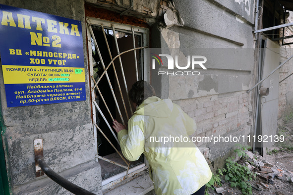 KHARKIV, UKRAINE - APRIL 27, 2024 - A woman looks inside through a grated window at Psychiatric Hospital N3 in the Saltivskyi district follo...