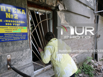 KHARKIV, UKRAINE - APRIL 27, 2024 - A woman looks inside through a grated window at Psychiatric Hospital N3 in the Saltivskyi district follo...