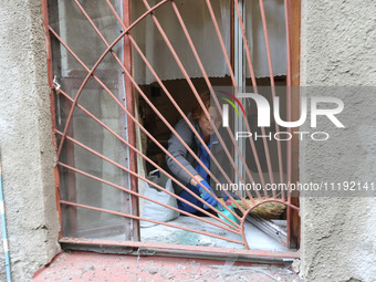 KHARKIV, UKRAINE - APRIL 27, 2024 - A woman collects glass shards on the windowsill at Psychiatric Hospital N3 in the Saltivskyi district fo...