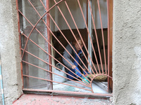 KHARKIV, UKRAINE - APRIL 27, 2024 - A woman collects glass shards on the windowsill at Psychiatric Hospital N3 in the Saltivskyi district fo...