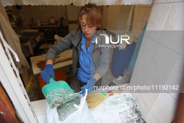 KHARKIV, UKRAINE - APRIL 27, 2024 - A woman collects glass shards on the windowsill at Psychiatric Hospital N3 in the Saltivskyi district fo...