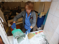 KHARKIV, UKRAINE - APRIL 27, 2024 - A woman collects glass shards on the windowsill at Psychiatric Hospital N3 in the Saltivskyi district fo...