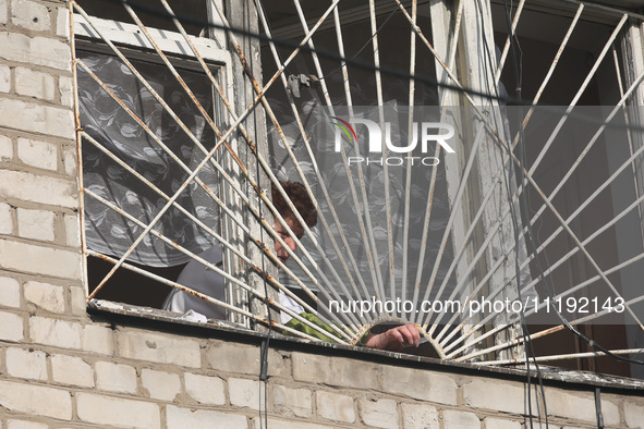 KHARKIV, UKRAINE - APRIL 27, 2024 - A woman collects glass shards on the windowsill at Psychiatric Hospital N3 in the Saltivskyi district fo...