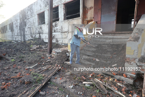 KHARKIV, UKRAINE - APRIL 27, 2024 - A man removes the soil from the steps at Psychiatric Hospital N3 in the Saltivskyi district following a...