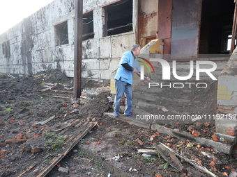 KHARKIV, UKRAINE - APRIL 27, 2024 - A man removes the soil from the steps at Psychiatric Hospital N3 in the Saltivskyi district following a...