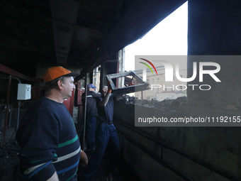 KHARKIV, UKRAINE - APRIL 27, 2024 - Men clean the premises of Psychiatric Hospital N3 in the Saltivskyi district following a nighttime Russi...