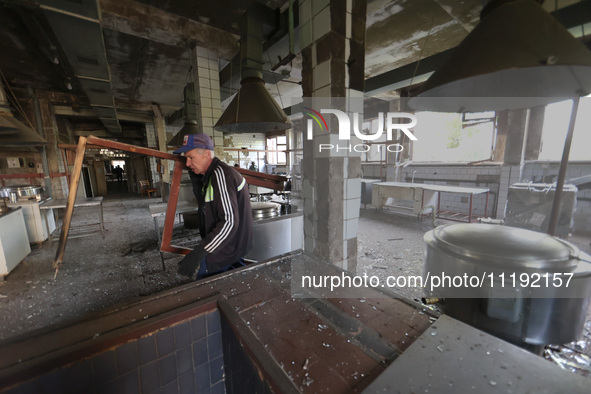 KHARKIV, UKRAINE - APRIL 27, 2024 - A man takes out a broken window frame at the food block of Psychiatric Hospital N3 in the Saltivskyi dis...