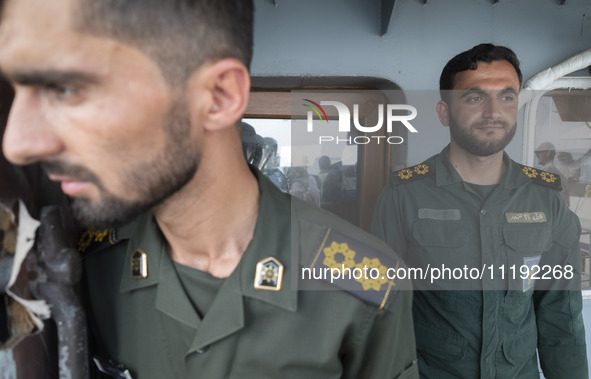 Two Islamic Revolutionary Guard Corps (IRGC) Navy military personnel are standing on a warship during the IRGC marine parade in honor of Per...