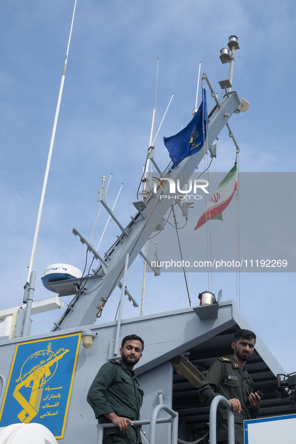 Two Islamic Revolutionary Guard Corps (IRGC) Navy military personnel are standing on a warship during the IRGC marine parade in honor of Per...