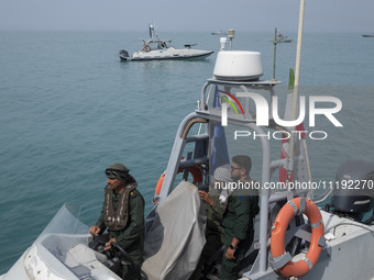 Islamic Revolutionary Guard Corps (IRGC) Navy military personnel are standing on a speed boat during the IRGC marine parade commemorating th...