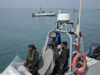 Islamic Revolutionary Guard Corps (IRGC) Navy military personnel are standing on a speed boat during the IRGC marine parade commemorating th...