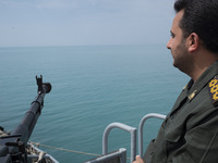 An Islamic Revolutionary Guard Corps (IRGC) Navy military personnel is standing on a warship and monitoring an area during the IRGC marine p...