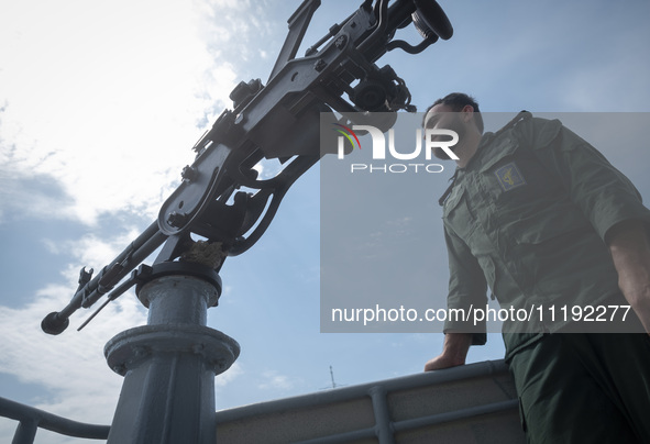 An Islamic Revolutionary Guard Corps (IRGC) Navy military personnel is monitoring an area while standing on a warship during the IRGC marine...