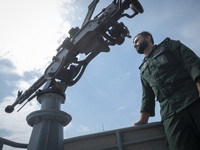 An Islamic Revolutionary Guard Corps (IRGC) Navy military personnel is monitoring an area while standing on a warship during the IRGC marine...