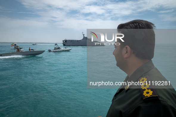 An Islamic Revolutionary Guard Corps (IRGC) Navy military personnel is standing on a warship and monitoring an area during the IRGC marine p...